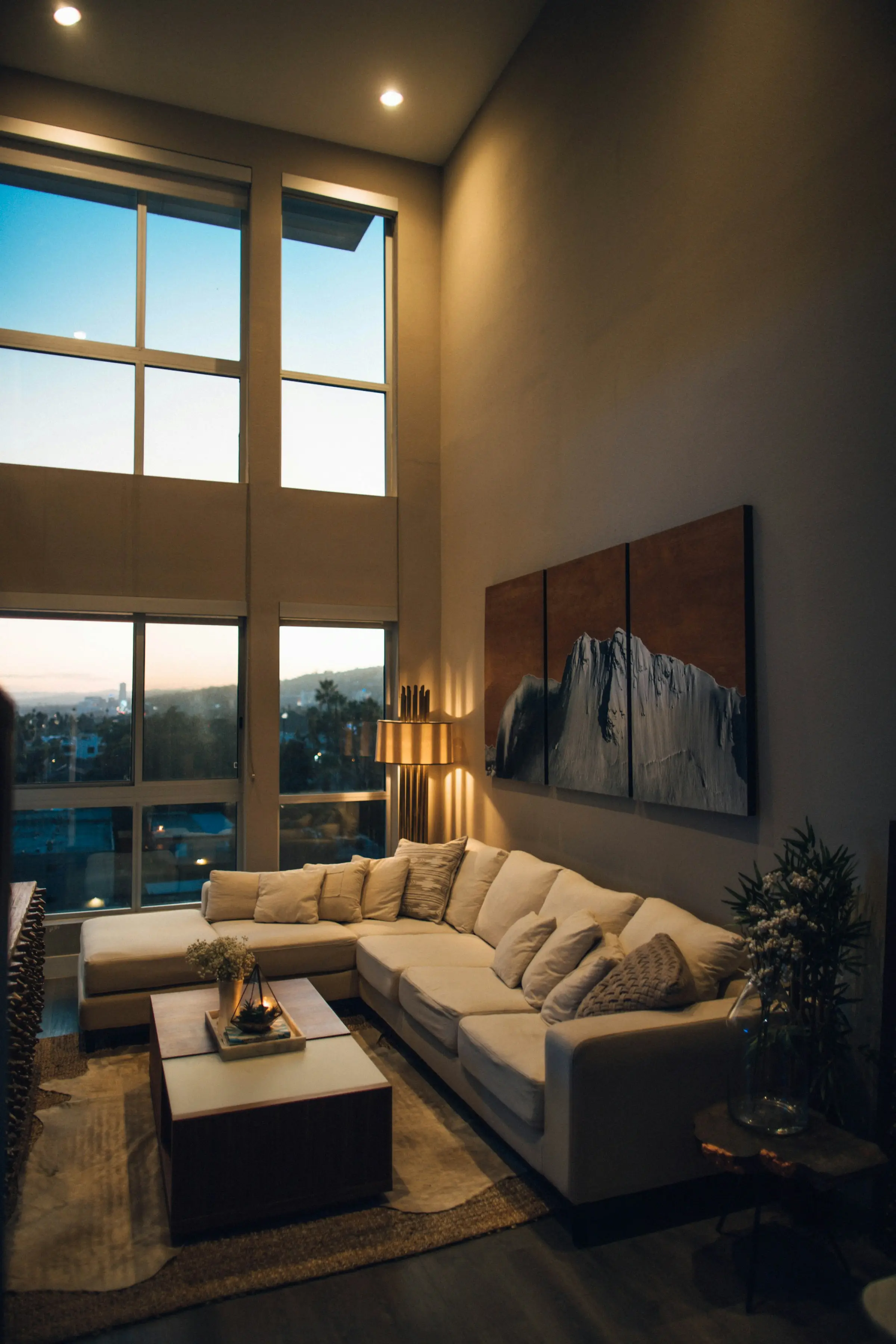 Apartment living room in warm evening light with a city view